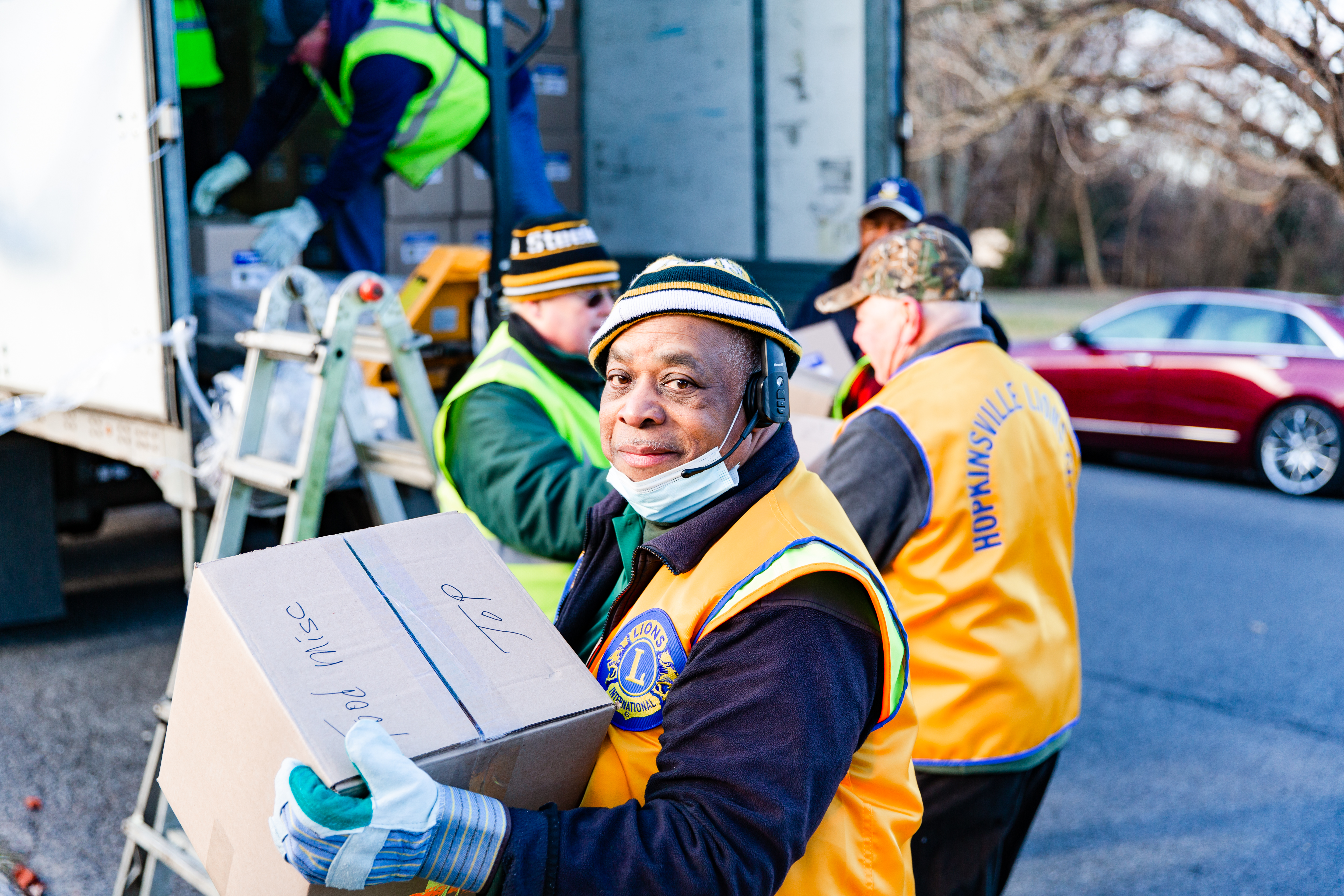 Lion member holding a box with food supplies