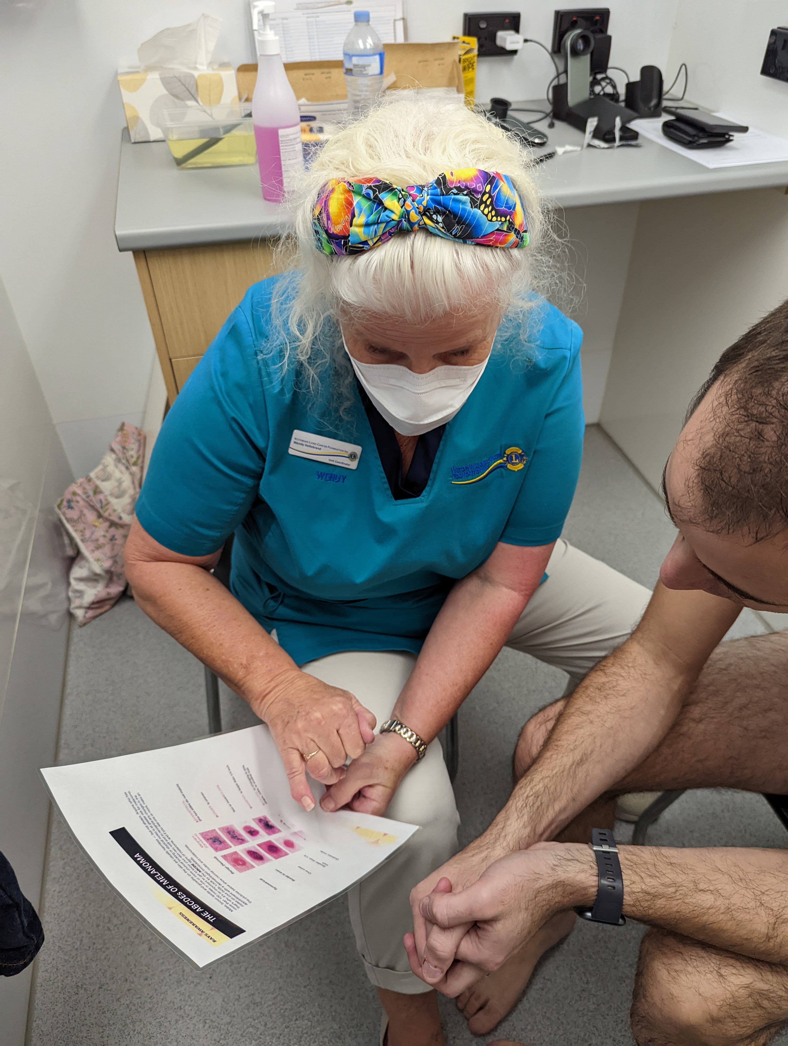 El personal de la furgoneta de detección de cáncer consulta con el beneficiario