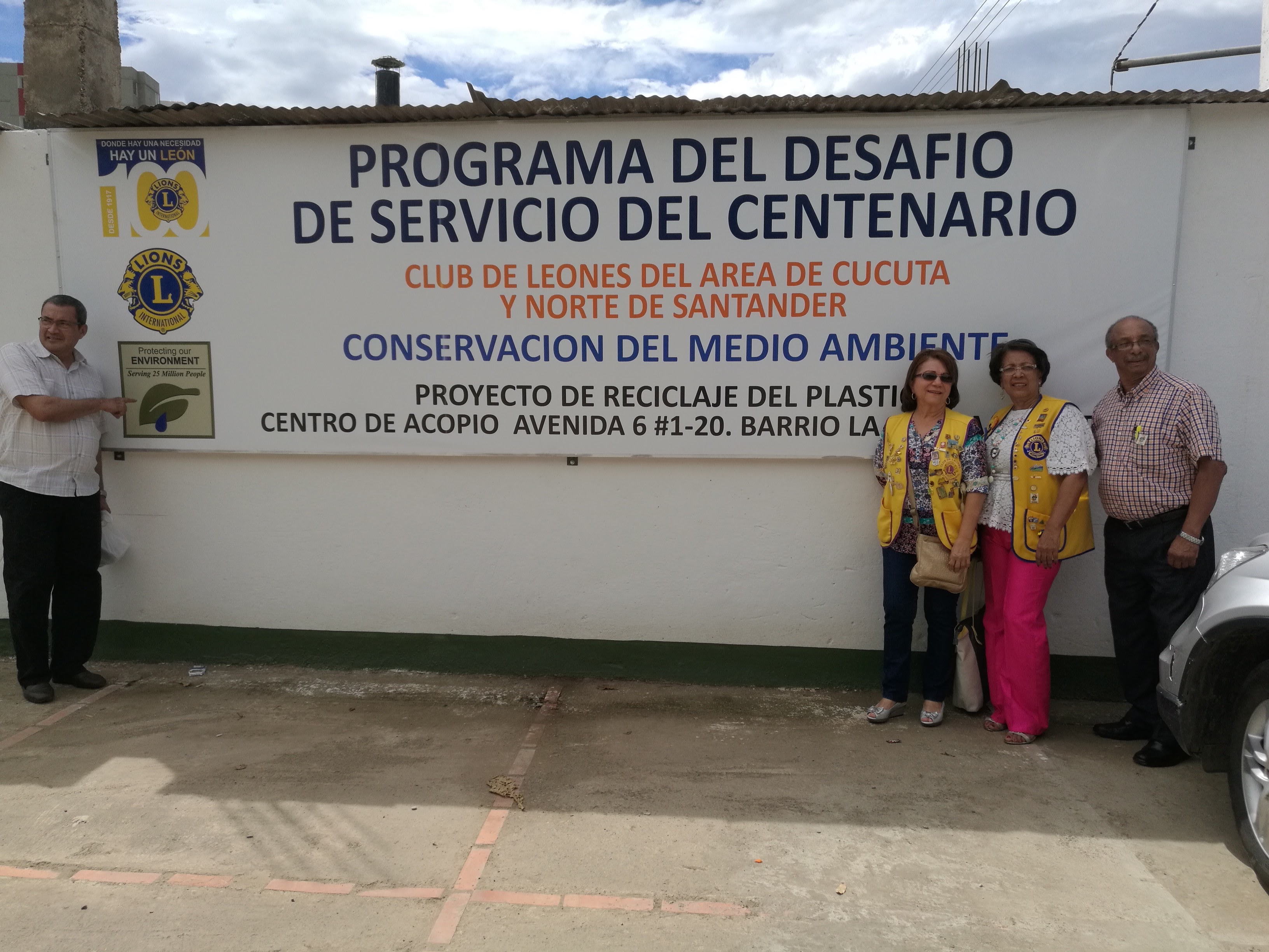 Lions in front of sign for their recycling project