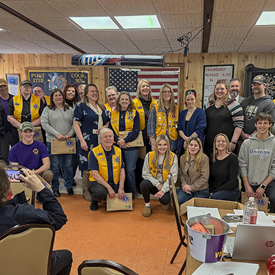 Mitglieder des Cook Lions Clubs versammeln sich im Gebäude, um ihre Leistungen bei Hilfsprojekten zu feiern und neue Mitglieder willkommen zu heißen.
