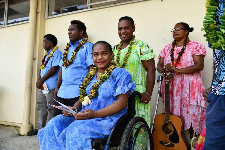 Clerence (pictured seated) smiles at the clinic’s inauguration ceremony.