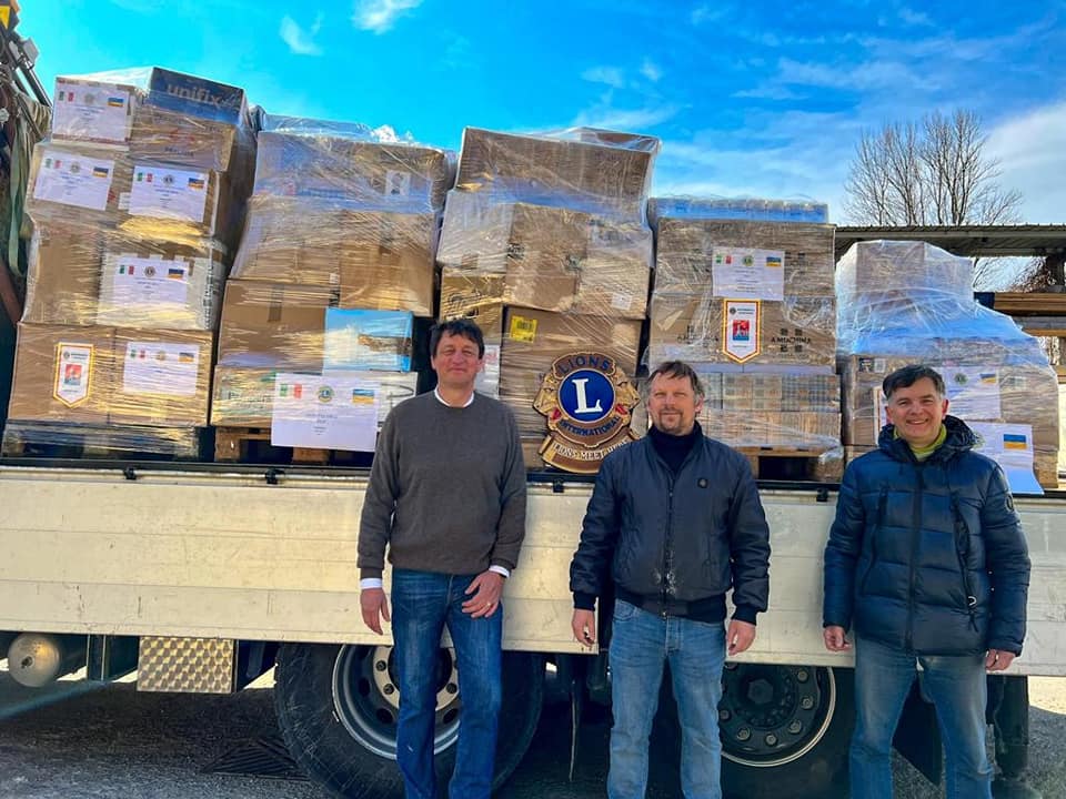 Picture of a truck with loads of humanitarian help and 3 volunteers