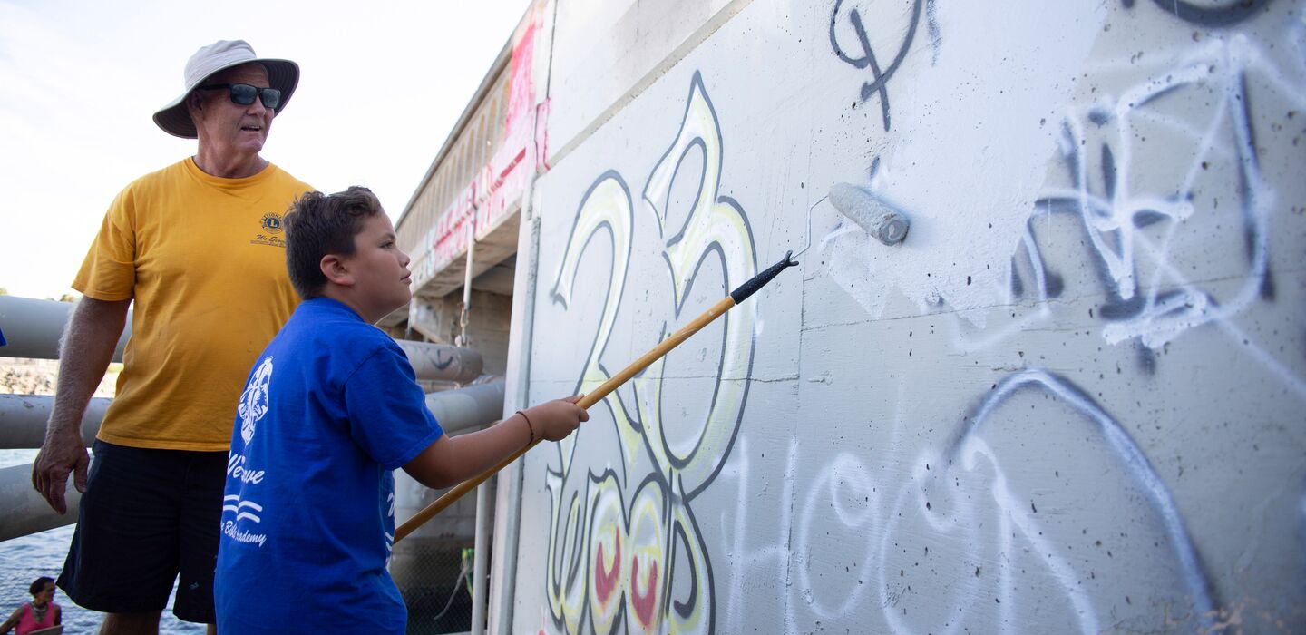 Associado Leão observando associado Leo no projeto de pintura sobre grafitti